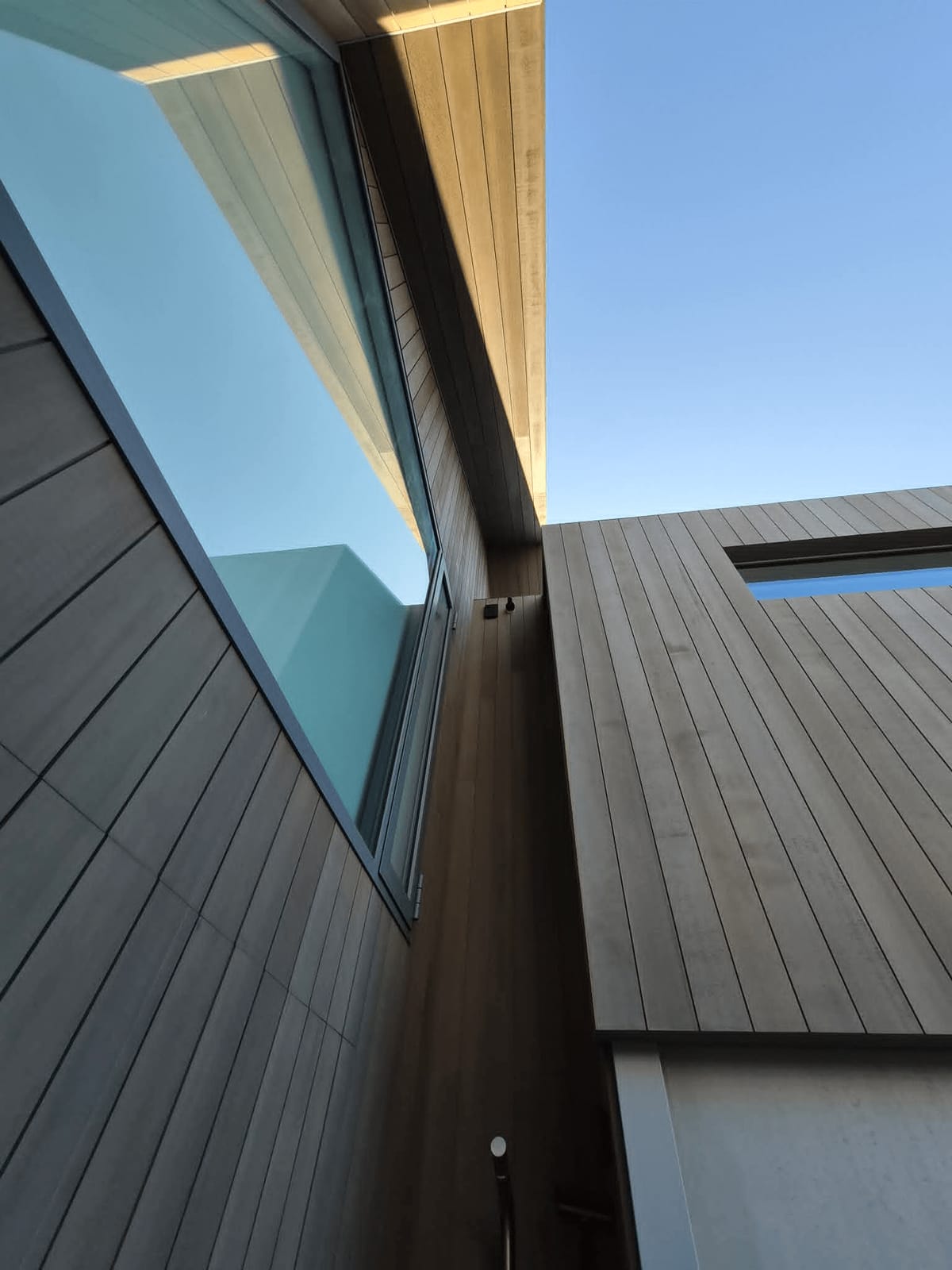 Vertical timber cladding, glazing and timber soffits on a modern two-storey home
